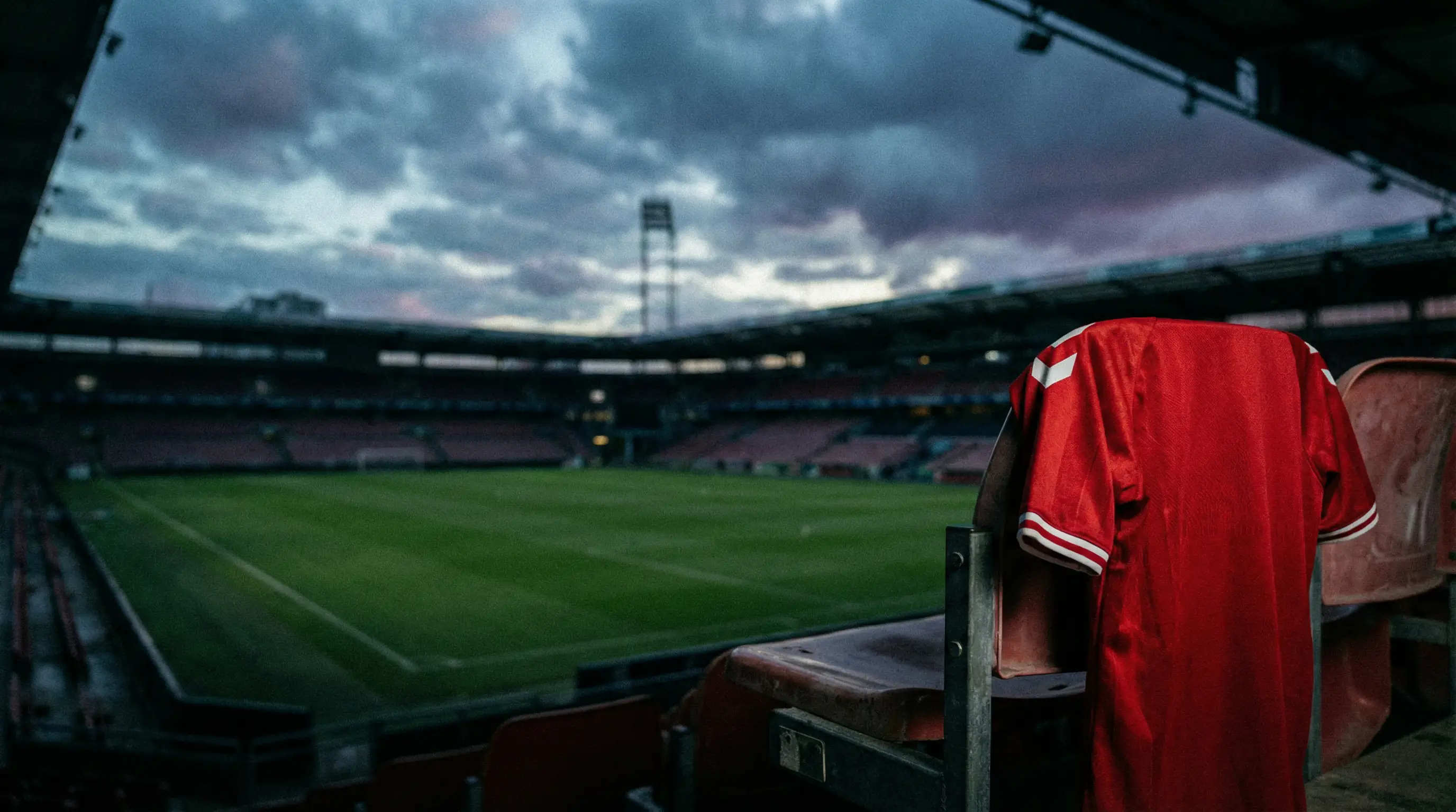 Dansk fodbold i krise — tomme sæder på Parken Stadium og et landsholdstrøje der hænger alene